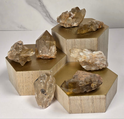 collection of citrine specimens on a wood base against a marbled white background