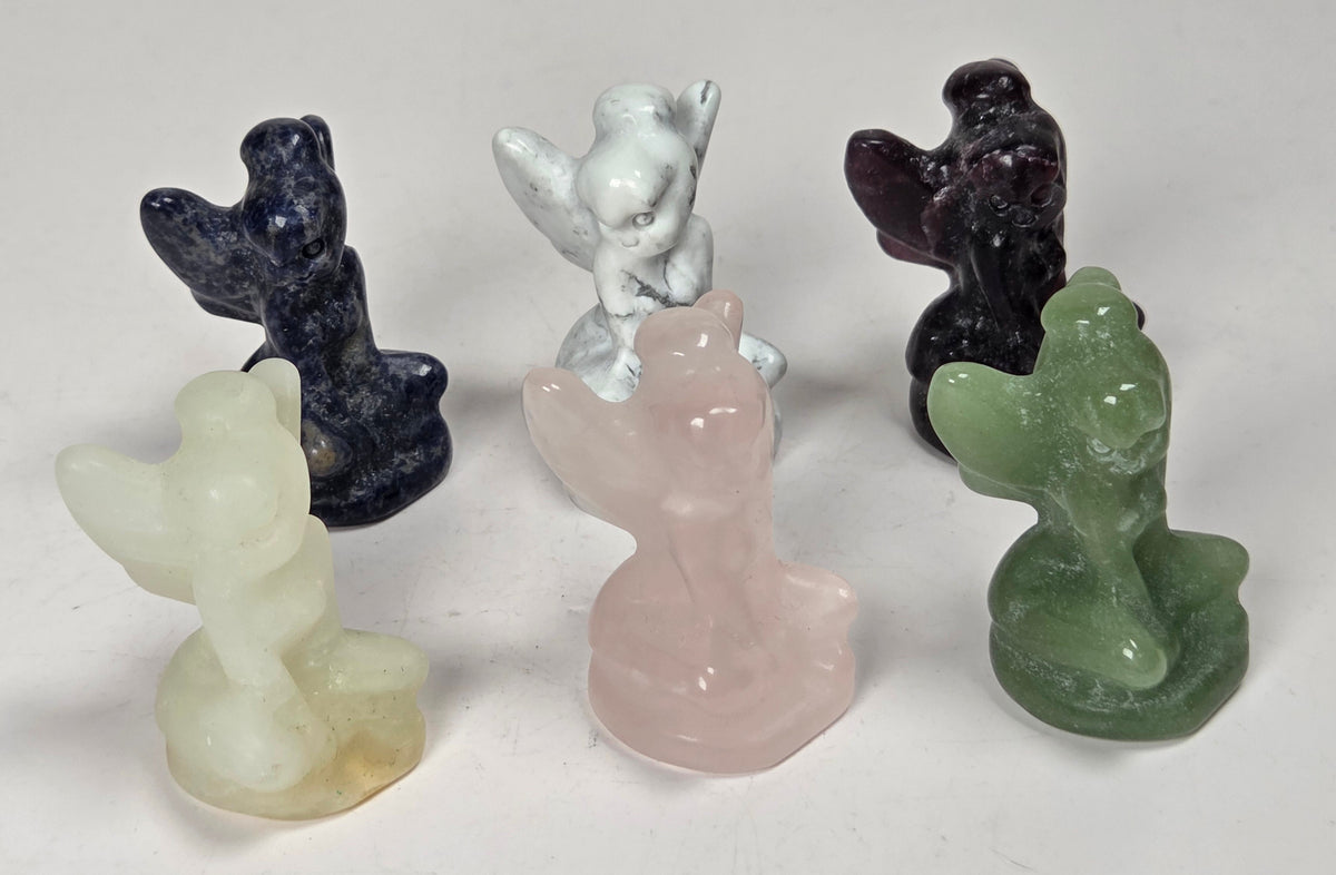 collection of tinkerbell carvings in a variety of materials on a white background