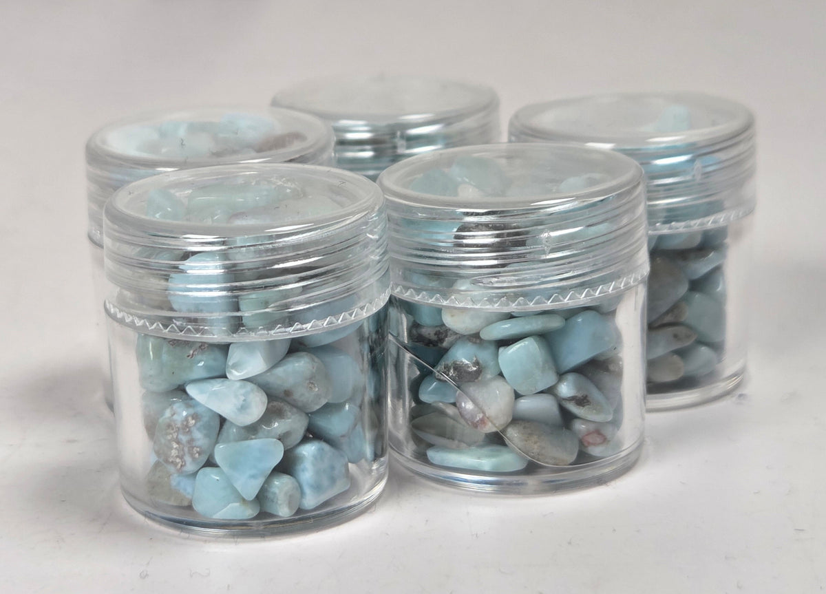 blue and white crystal chip in small plastic containers against a marbled background
