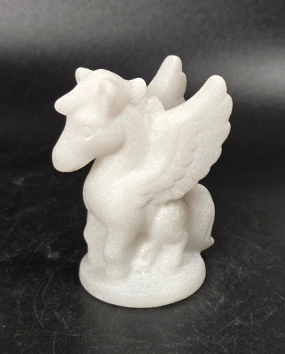 Stone sculpture of a winged creature on a black background