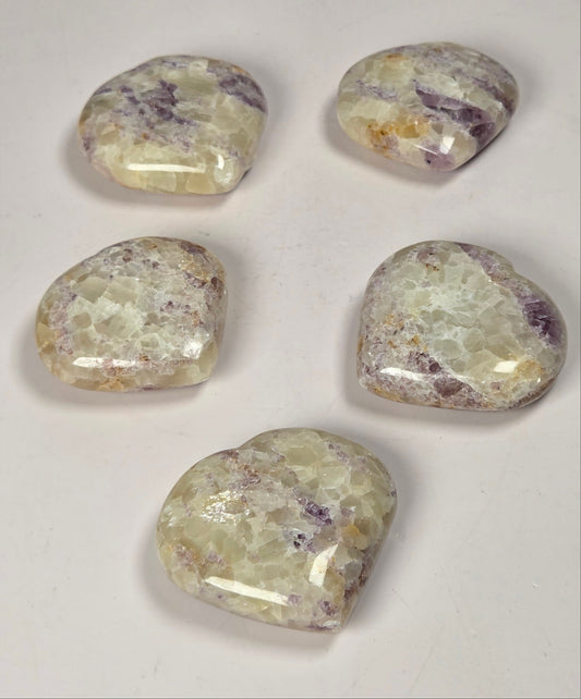 Set of white crystal hearts with some purple bands of color against a white background