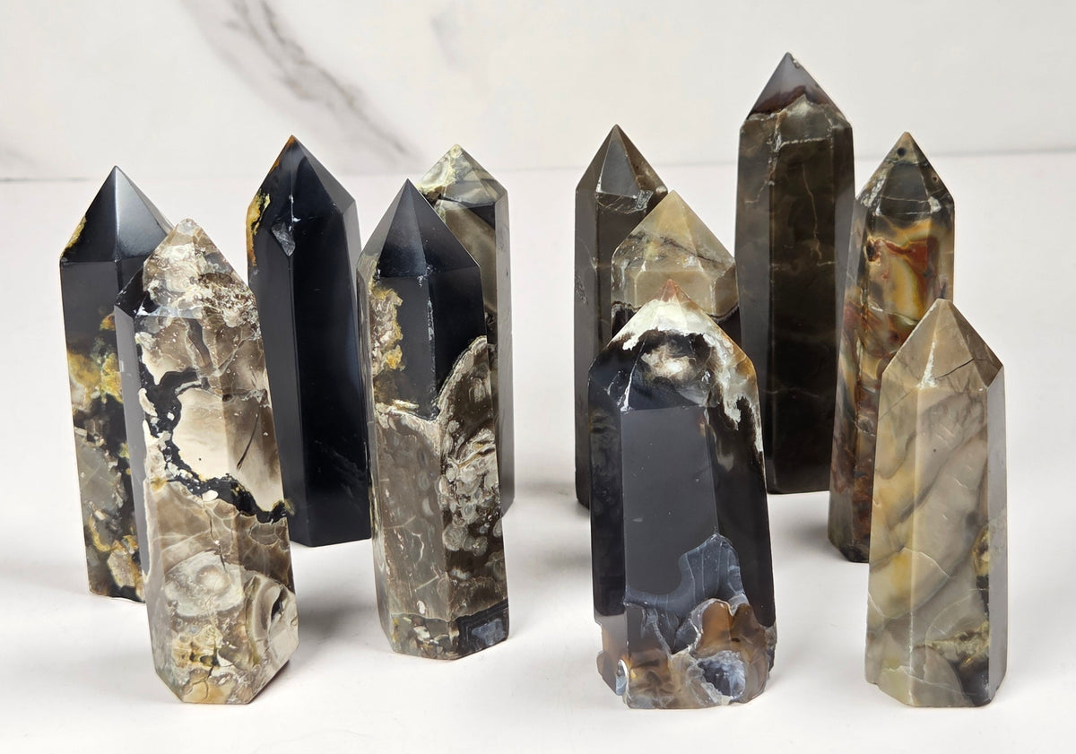 Collection of Volcano Agate polished points with tan and black coloring against a marbled background
