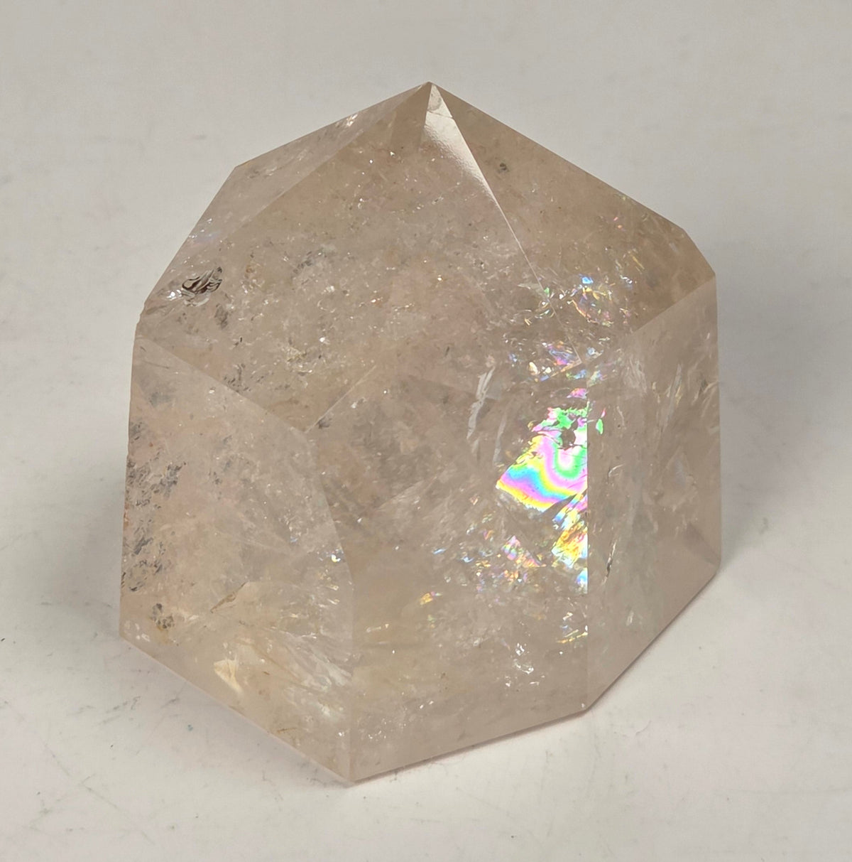Clear Quartz polished tower with lots of rainbows on a white background