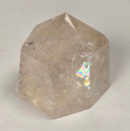Clear Quartz polished tower with lots of rainbows on a white background