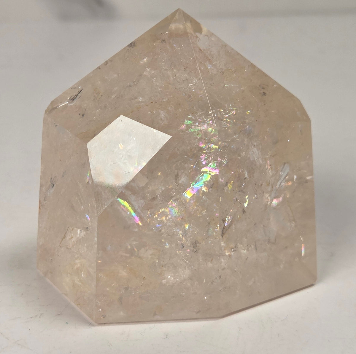 Clear Quartz polished tower with lots of rainbows on a white background