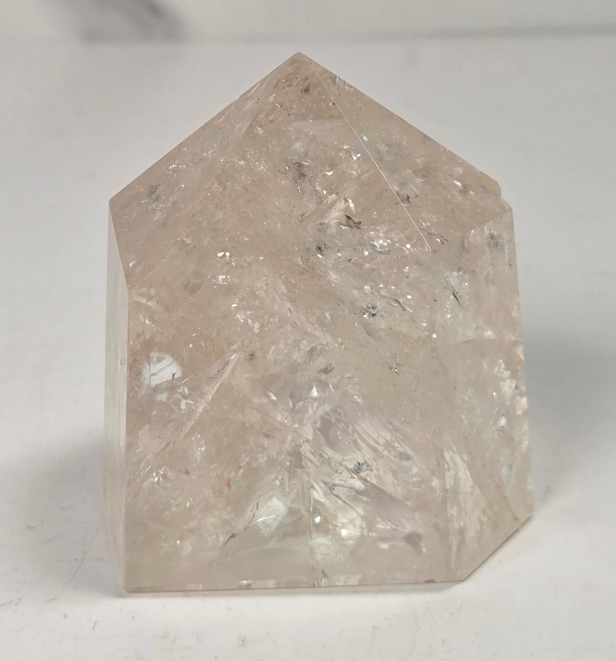 Clear Quartz polished tower with lots of rainbows on a white background