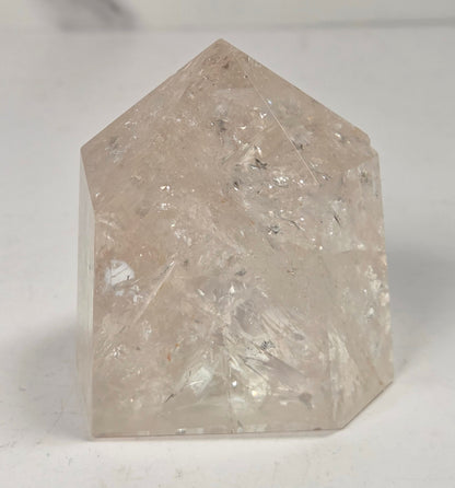 Clear Quartz polished tower with lots of rainbows on a white background