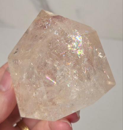 Clear Quartz polished tower with lots of rainbows on a white background
