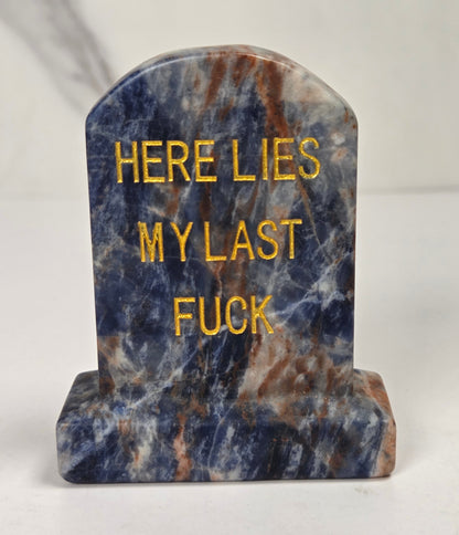 Blue and white crystal tombstone carving with gold lettering against a white background