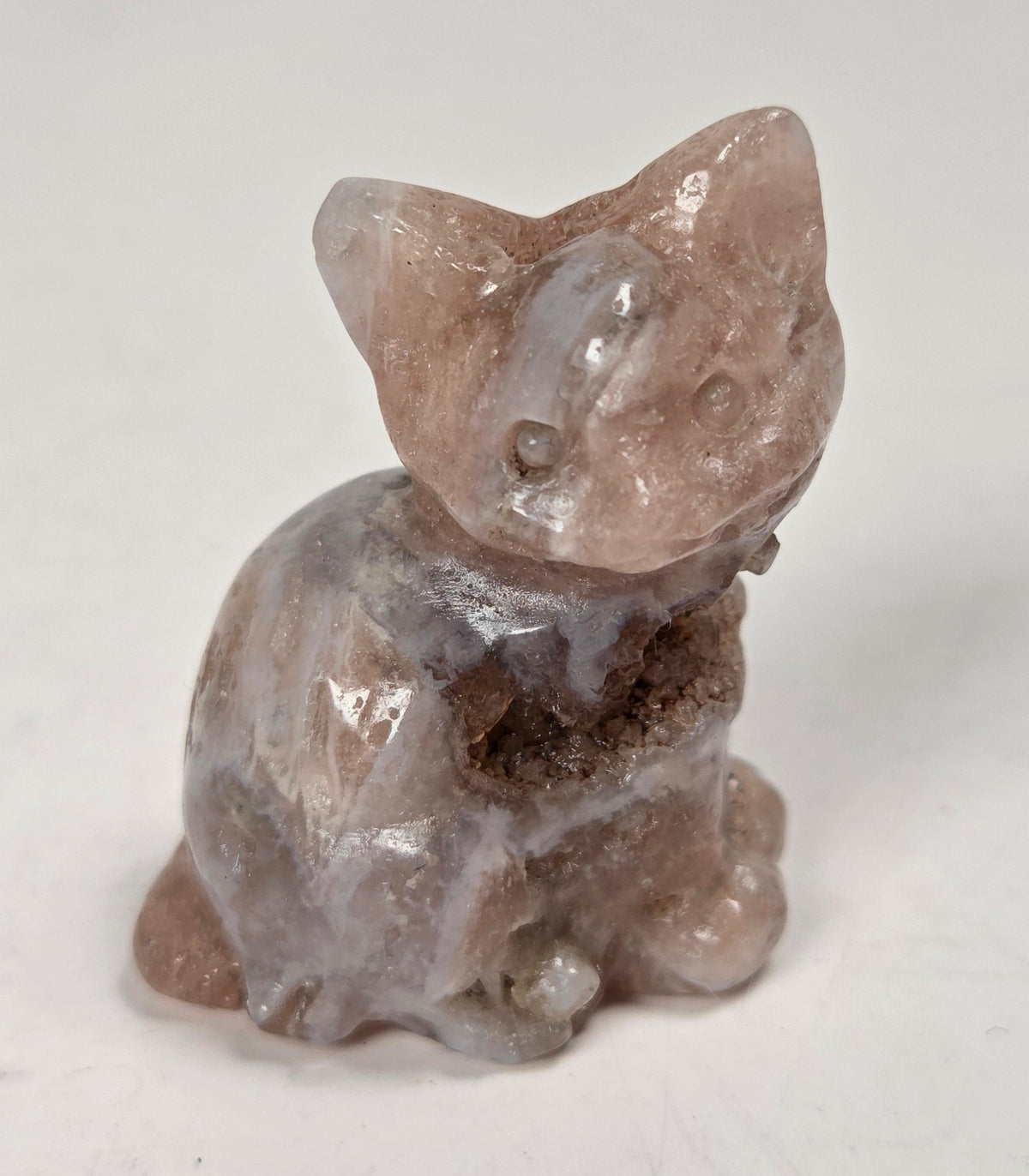 pink crystal carving of a cat against a white background