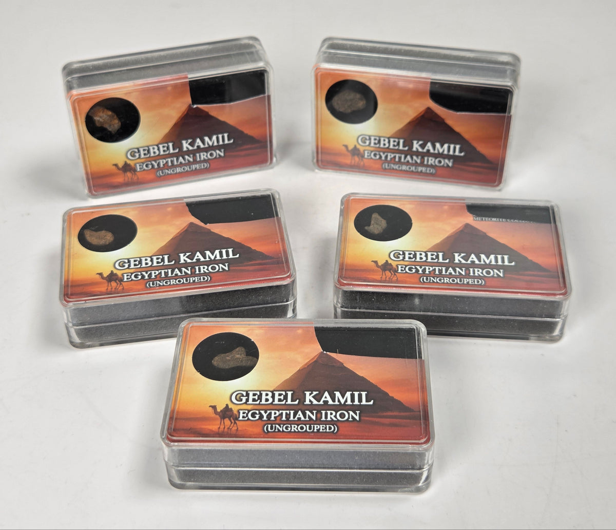 clear boxes with meteorite specimens against a white background