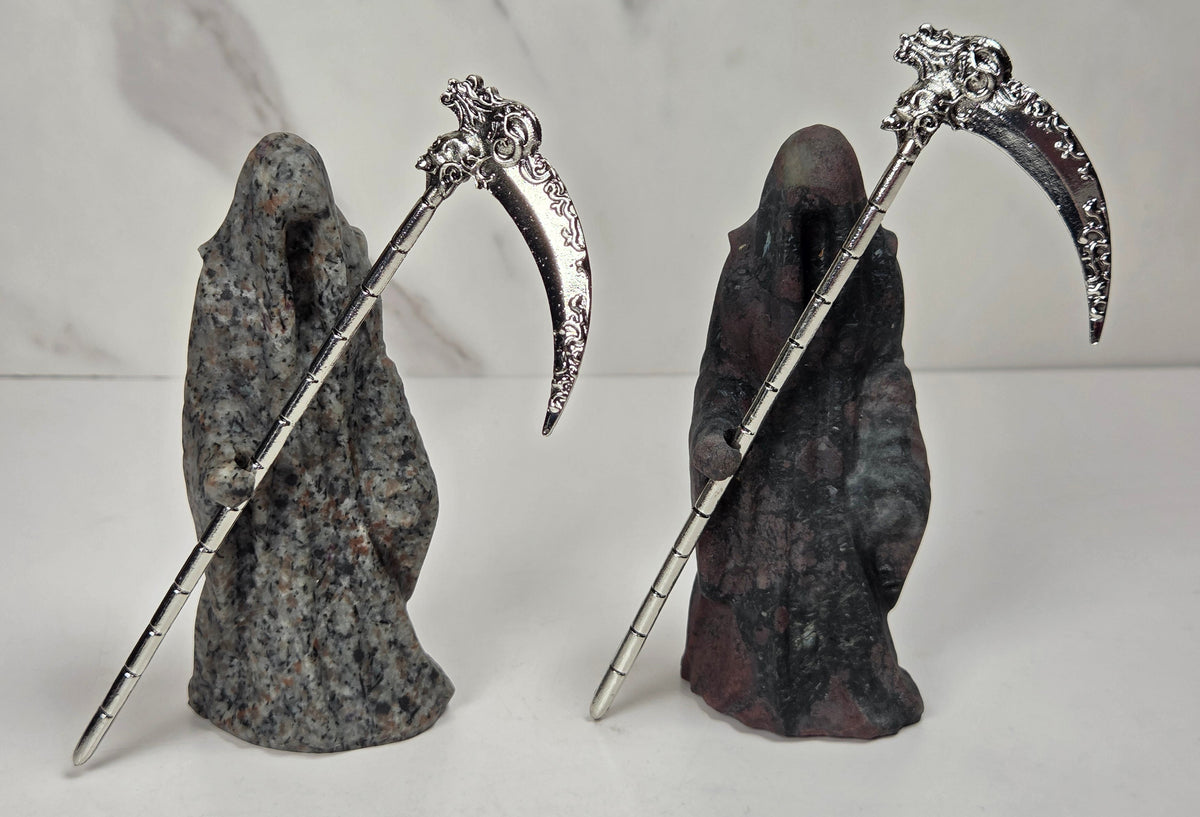Reaper style crystal carvings in a variety of materials with metal scythes against a marbled background
