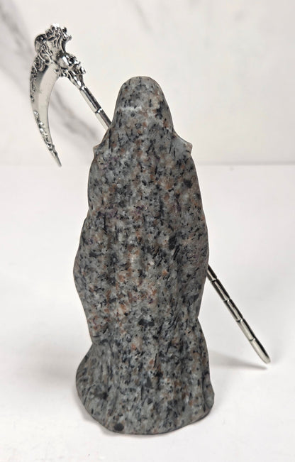 Reaper style crystal carving with black and grey coloring with a metal scythe against a marbled background