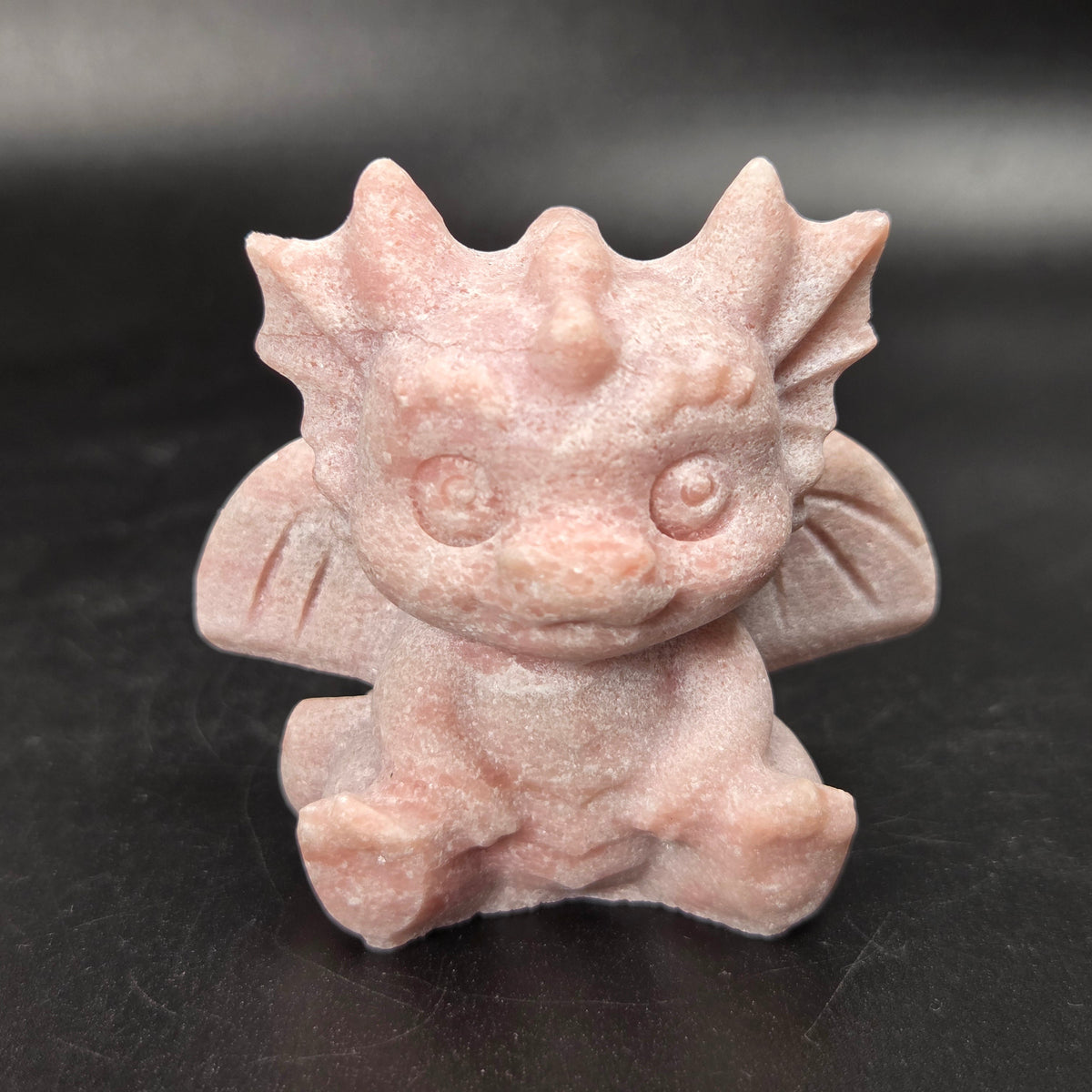 A small crystal dragon figurine against a dark background.
