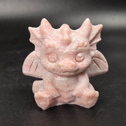 A small crystal dragon figurine against a dark background.