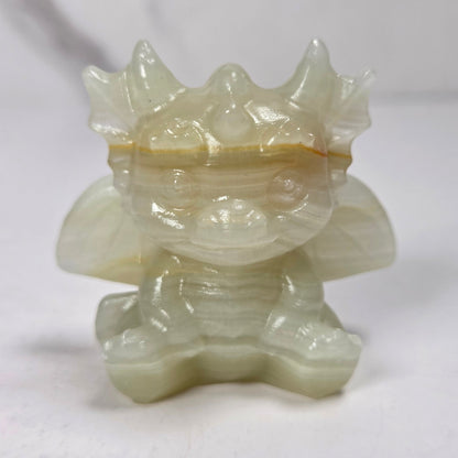 A small crystal dragon figurine against a dark background.