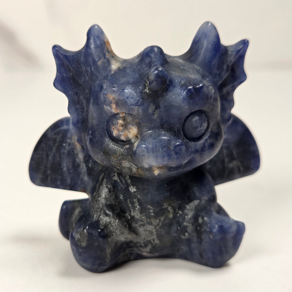 A small crystal dragon figurine against a white background.