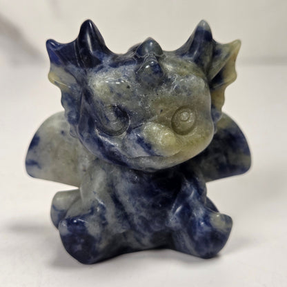 A small crystal dragon figurine against a white background.