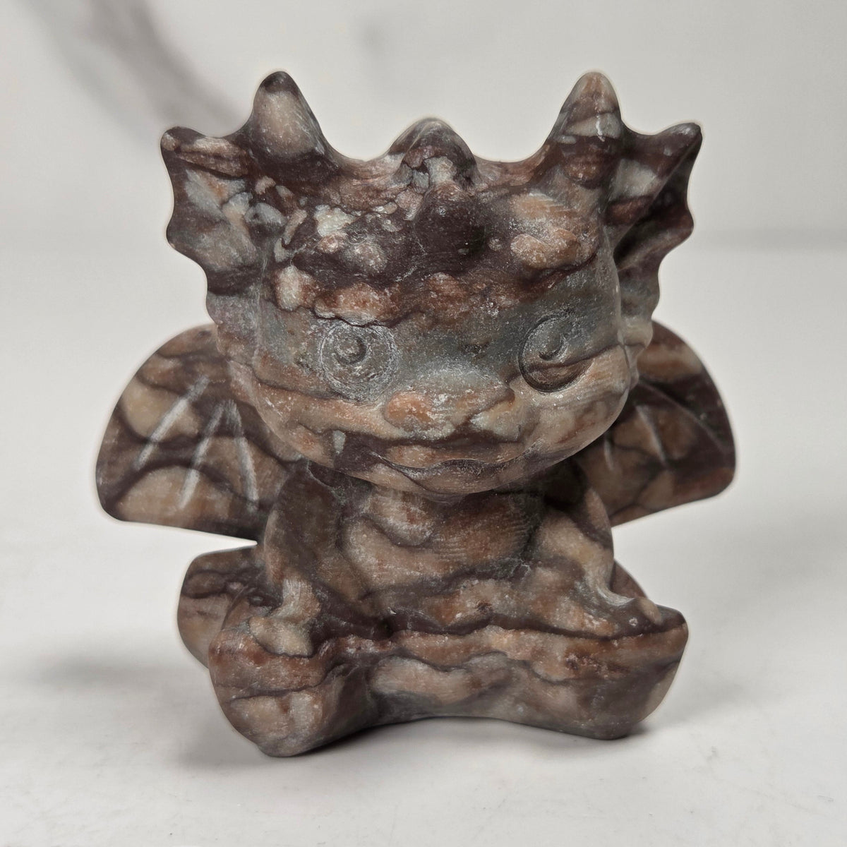 A small crystal dragon figurine against a white background.