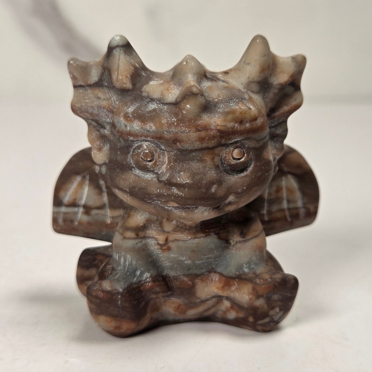 A small crystal dragon figurine against a white background.