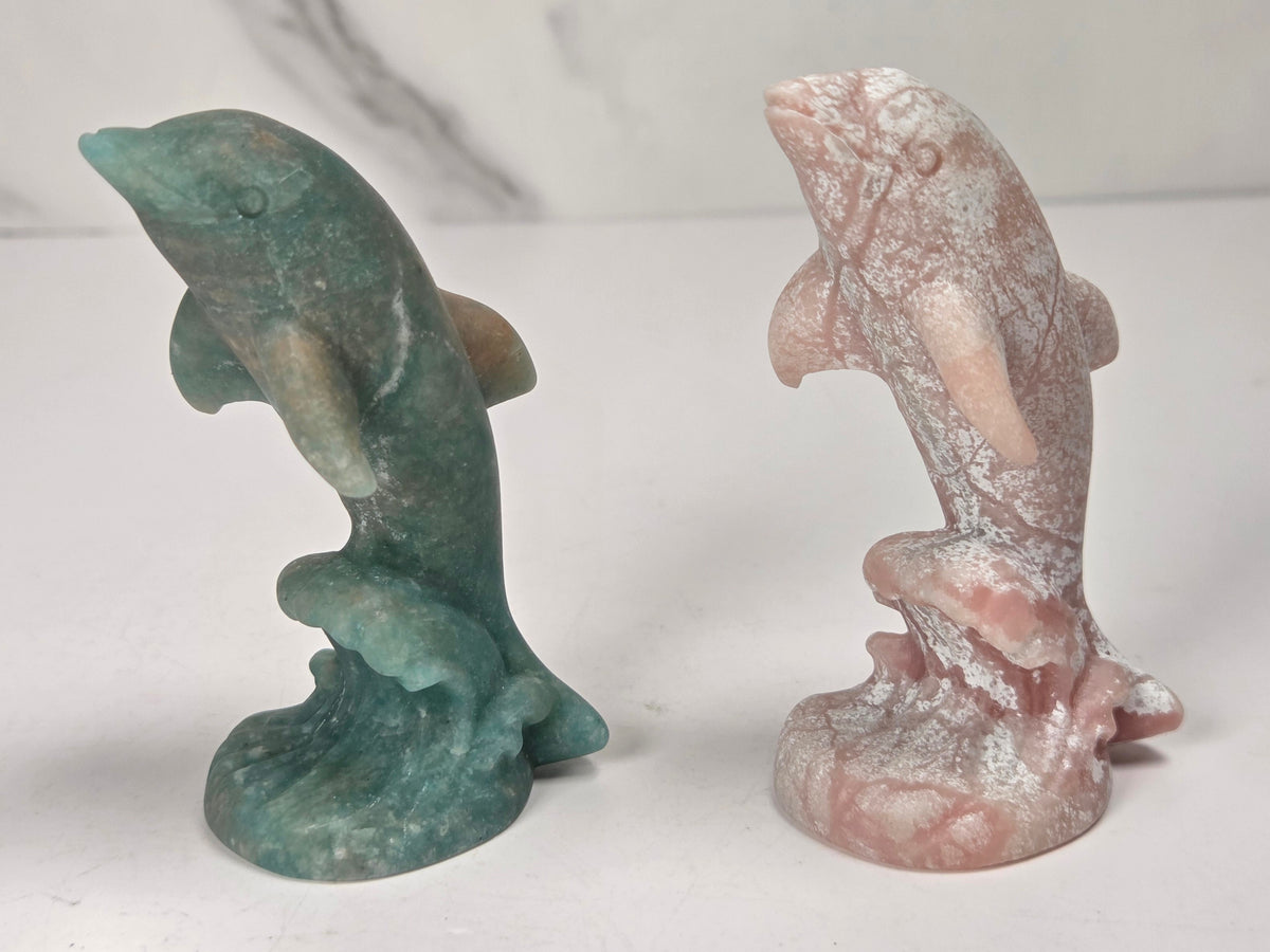 Dolphins on wave carvings in a variety of crystals and colors against a marbled background
