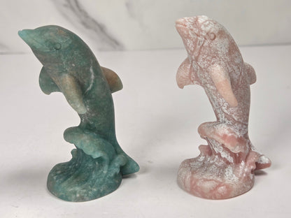 Dolphins on wave carvings in a variety of crystals and colors against a marbled background