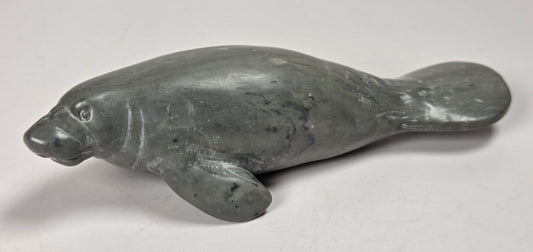 Grey crystal manatee carving against a white background