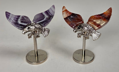 crystal wings of varying materials and colors with a silver eagle on a silver stand against a white background