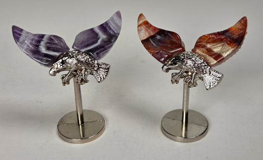 crystal wings of varying materials and colors with a silver eagle on a silver stand against a white background