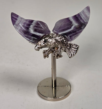 Purple and white crystal wings with a silver eagle on a silver stand against a white background