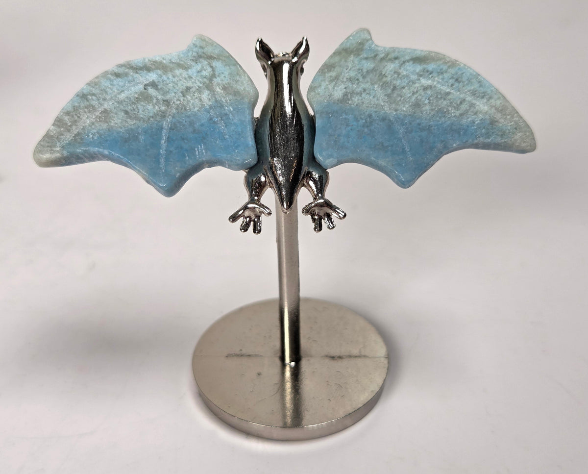 Blue crystal bat wings on a silver stand against a white background