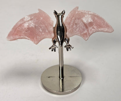 Pink crystal bat wings on a silver stand against a white background
