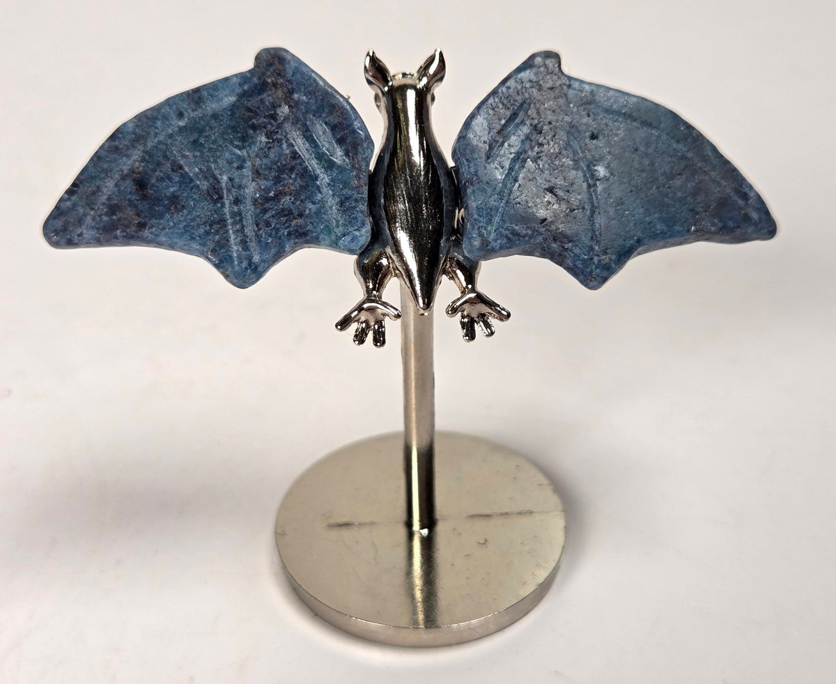 Blue crystal bat wings on a silver stand against a white background