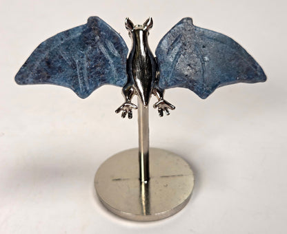 Blue crystal bat wings on a silver stand against a white background