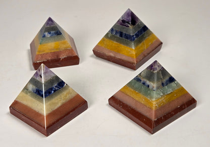 Rainbow colored  crystal pyramid carvings on a white background