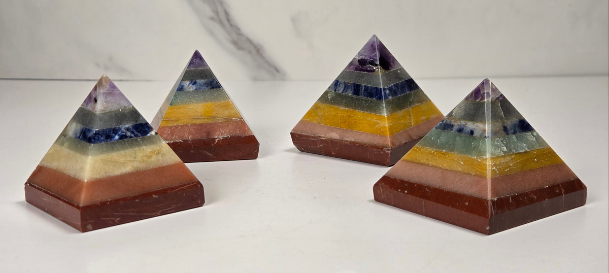 Rainbow colored  crystal pyramid carvings on a white background