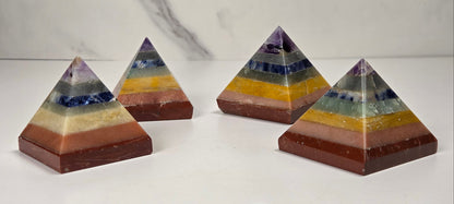 Rainbow colored  crystal pyramid carvings on a white background