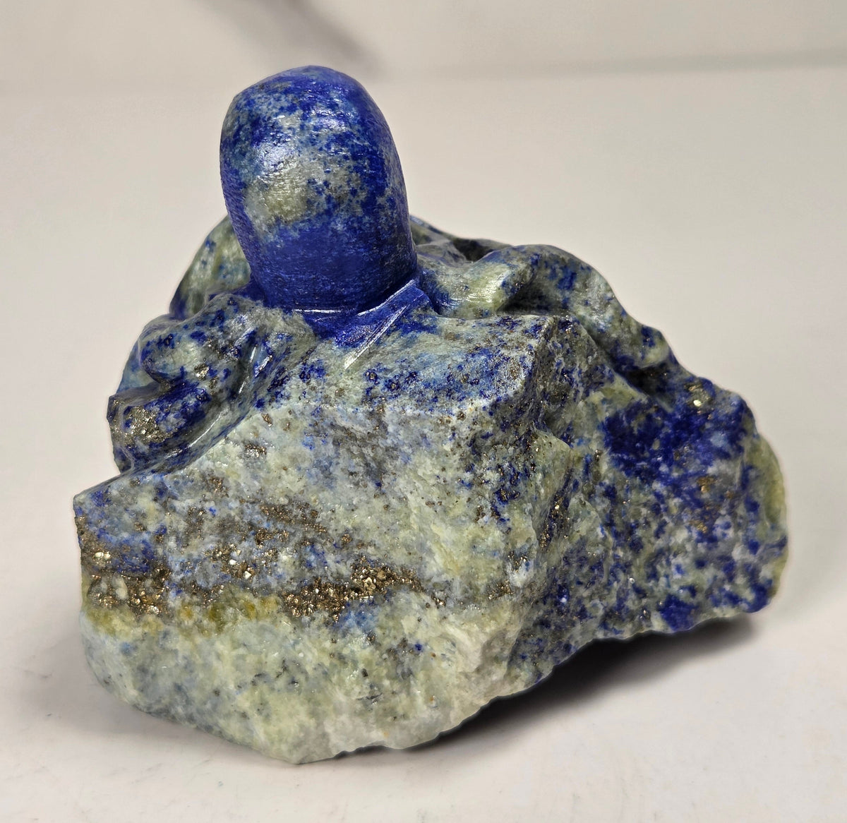 Blue crystal octopus carving with green  eyes against a marbled background