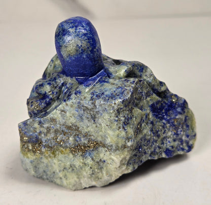 Blue crystal octopus carving with green  eyes against a marbled background
