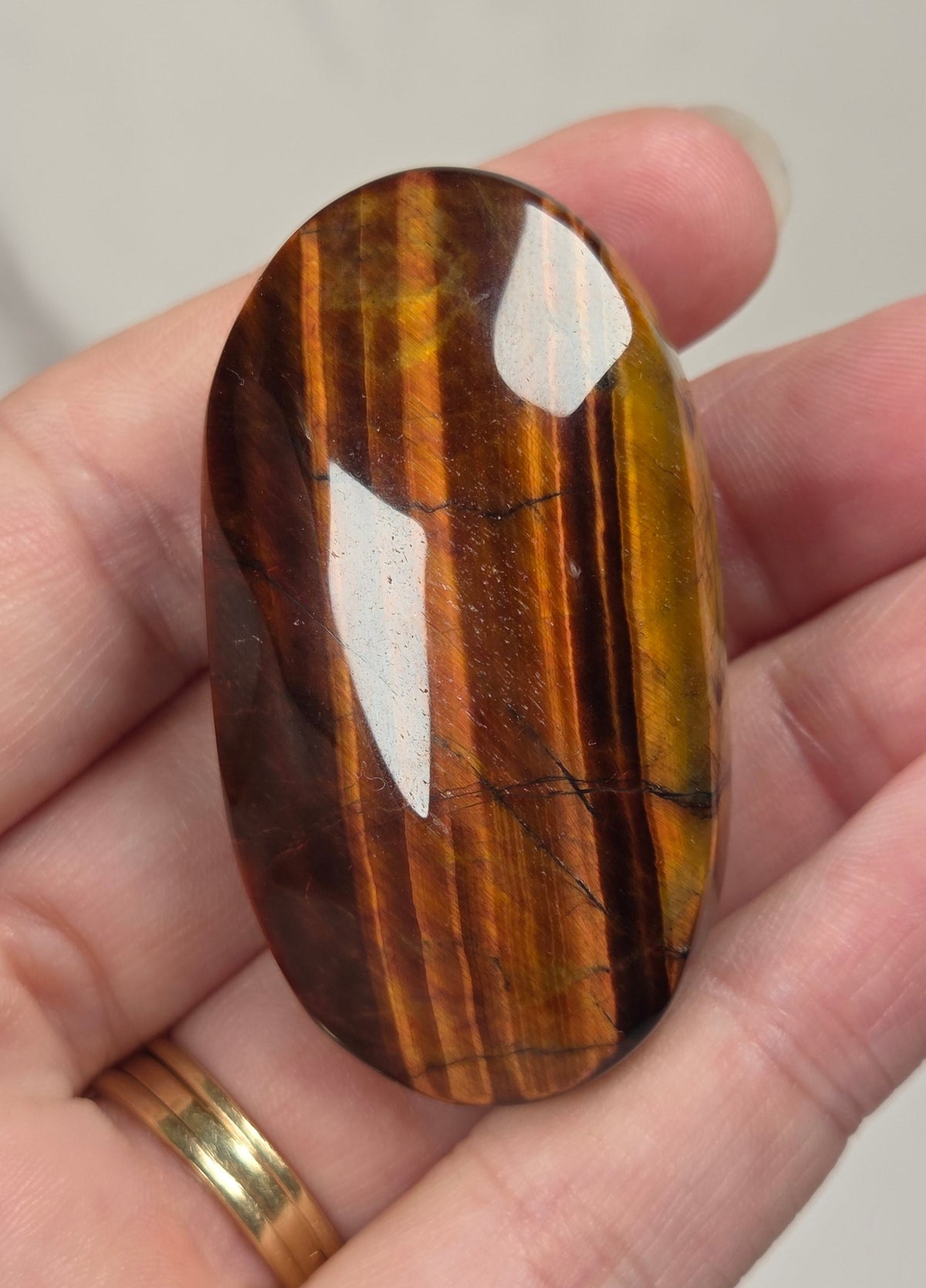 collection of red tigers eye crystal carvings with bands against a white background