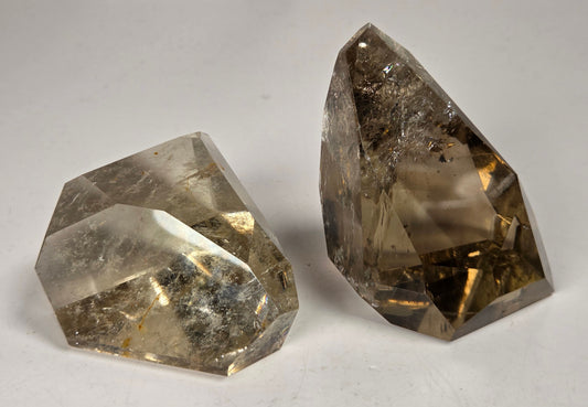 Smoky Quartz polished free forms against a white background