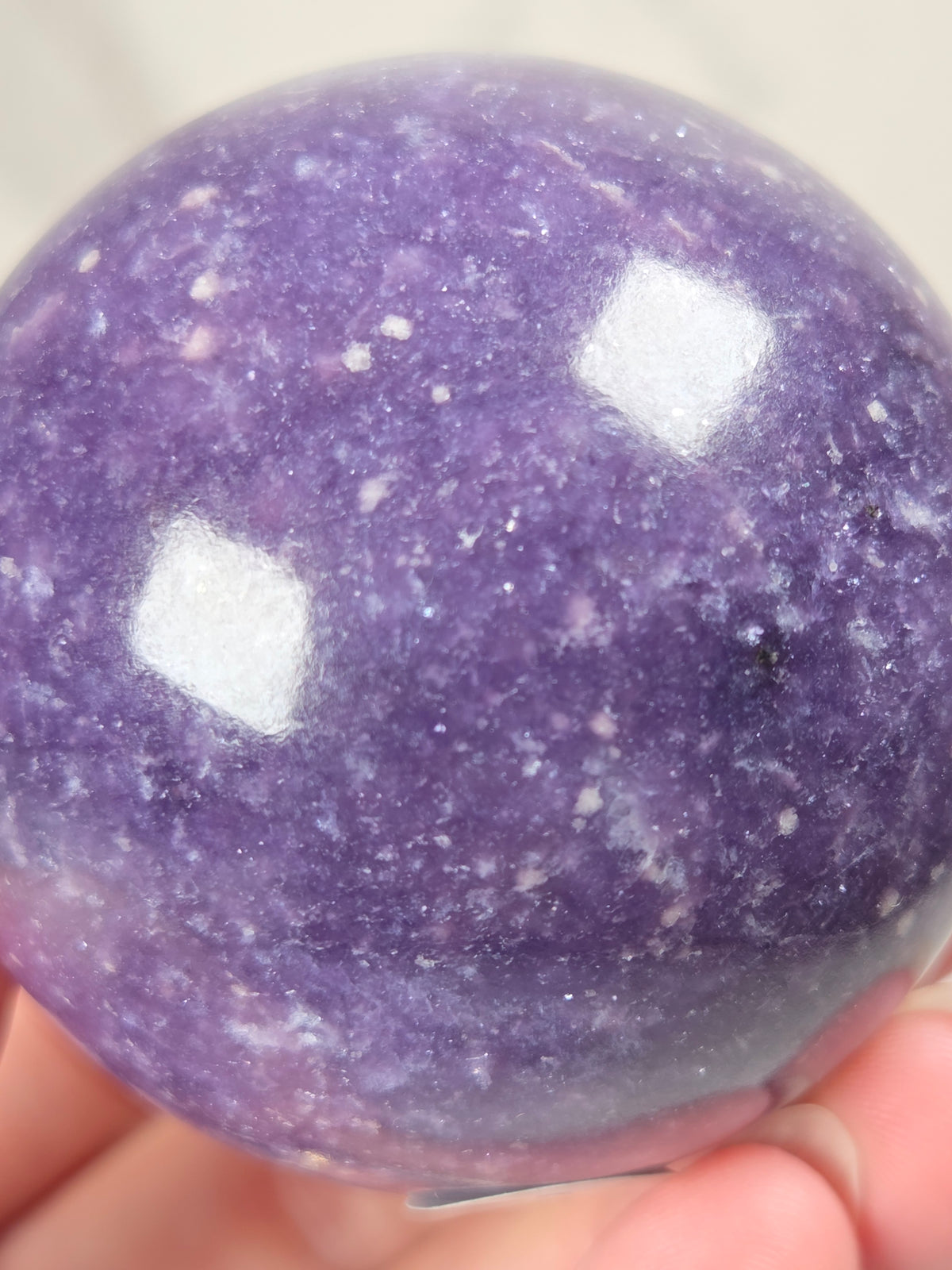 Close up of a Purple crystal sphere carving  against a white background