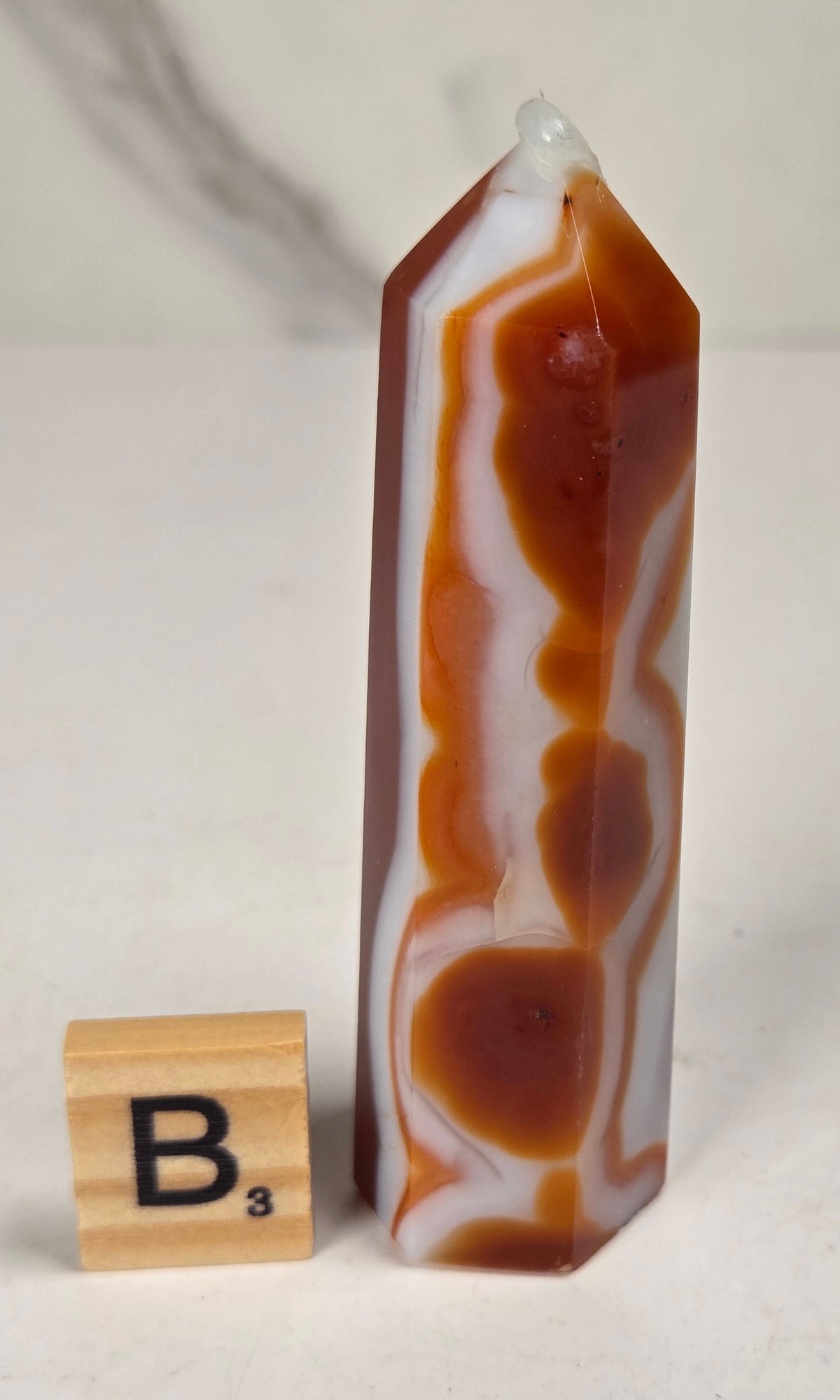 Polished carnelian crystal towers with beautiful white and red banding against a marbled background