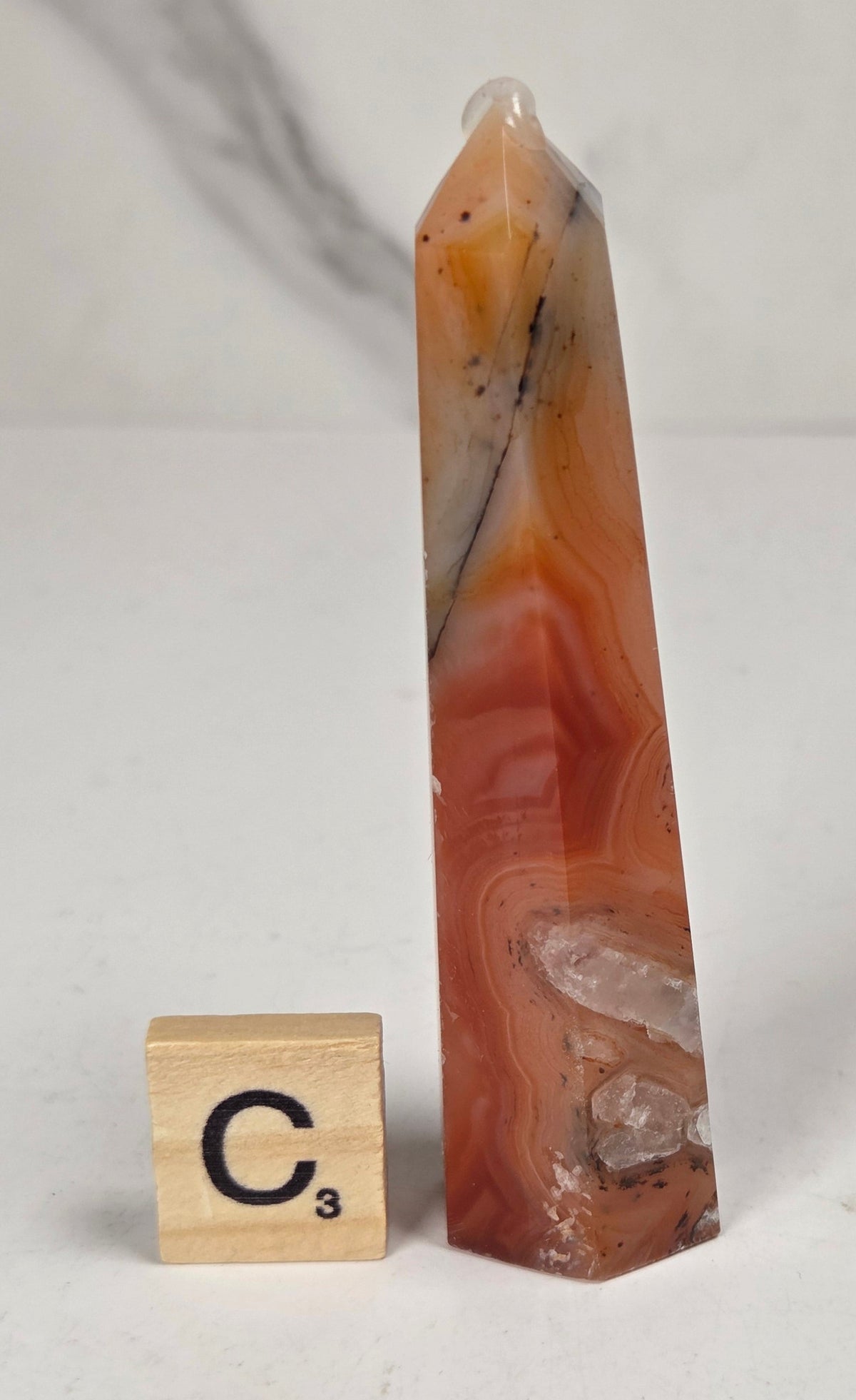 Polished carnelian crystal towers with beautiful white and red banding against a marbled background