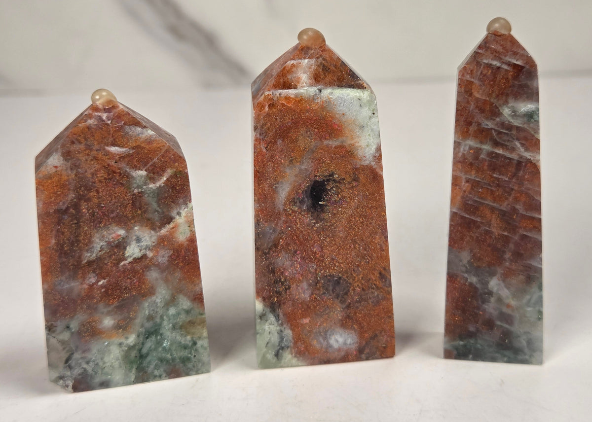 Orange crystal polished towers with white coloring against a white background