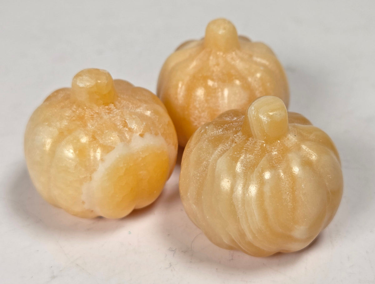Collection of orange calcite crystal pumpkins on a white background