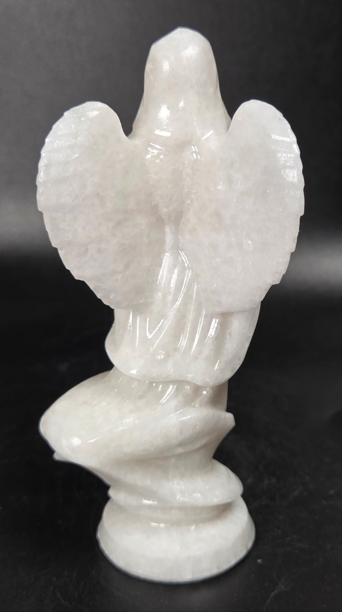 White Jade crystal carving of a woman wearing a robe and angel wings against a white background