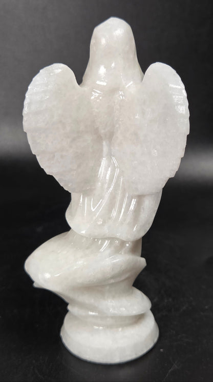White Jade crystal carving of a woman wearing a robe and angel wings against a white background