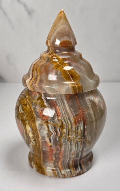 banded calcite candy jars with green, brown and red banding against a marbled background