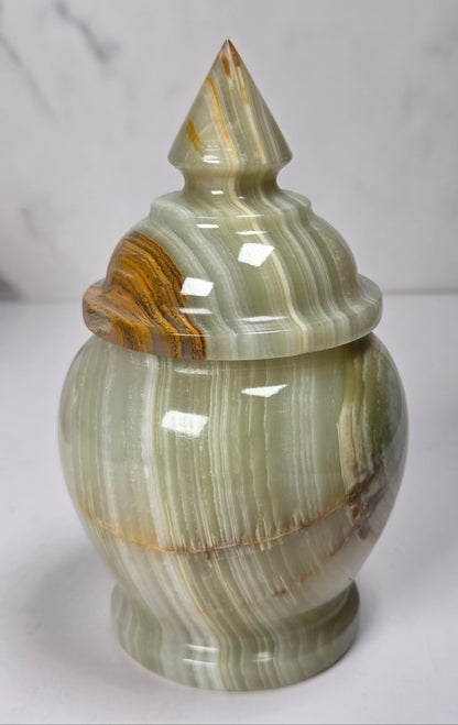 banded calcite candy jars with green, brown and red banding against a marbled background